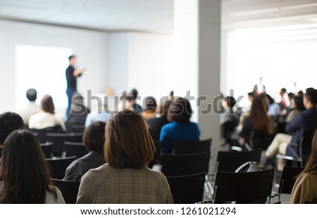 Presenter Presenting Presentation to Conference Audience. De-focused Blurred . Lecturer on Stage at Tech Forum. Speaker Giving Speech in Conference Hall Auditorium. Copy Space Screen Background. Royalty-Free Stock Photo #1261021294