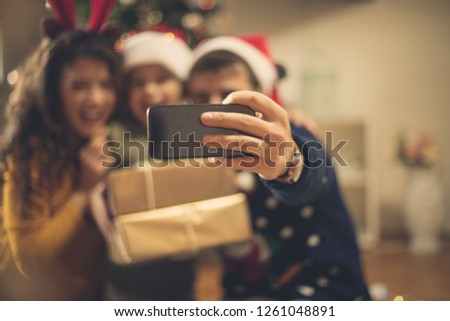 Let your smiles be preserved in the pictures. Family taking self portrait for Christmas day. Focus on hand. Close up.