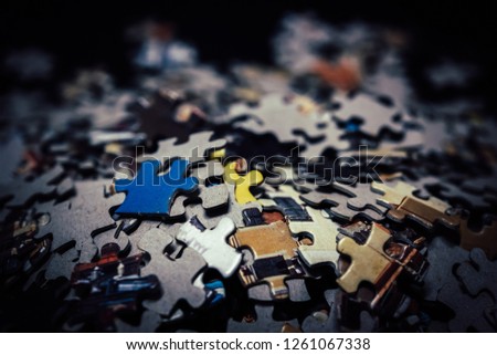 Close up piece of wooden jigsaw puzzle as a concept of business success in challenge completion with teamwork. Selective focus of pieces jigsaw puzzle background.