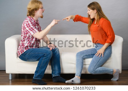 Man and woman having horrible fight while sitting on sofa. Friendship, couple breakup difficulties and problems concept. Royalty-Free Stock Photo #1261070233