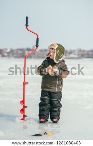 boy fishing on winter. Cute boy catches fish in the winter lake. Winter. Outdoor