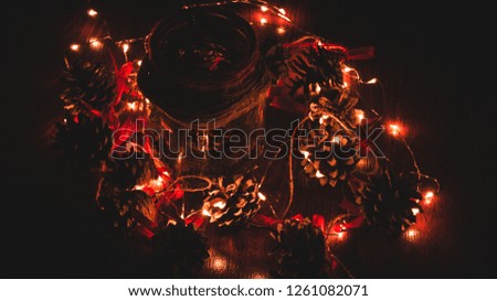 Christmas, New Year. Bank with cones. Dark background. Defocusing. Glowing garland.