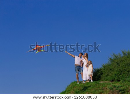 Beautiful happy family play with kite, has fun emotions. Portrait in nature landscape. Holiday style view. Amazing festival people. Children and adult hobby. 