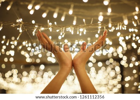 woman hand holding string vintage LED christmas lights with blurred and bokeh background