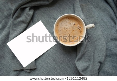 A cup of cooffee on textile grey background with lights and copyspace. Coffee time. Flat lay style.