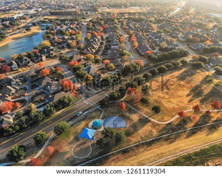 Flyover beautiful neighborhood situated between lake and community park surrounded by colorful autumn trees. Environmental friendly subdivision in Irving, suburbs Dallas, Texas, USA