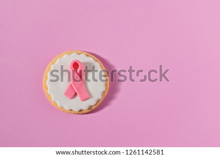 Cookies with pink ribbon as sign of the fight against breast cancer. Concept of International Cancer Day 4 February, flat lay greeting card, copy space