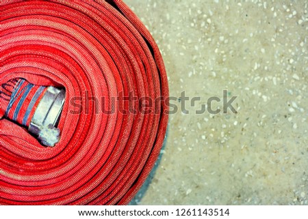 Red fire hose twisted into a spiral. Top view with copy space. 