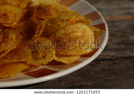 close up of thin crispy banana on wooden table background the concept of processing food banana products
