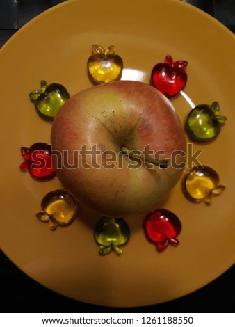 Apples toys on yellow plate.