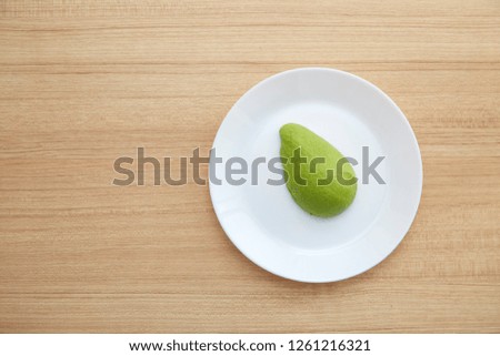 Healthy vegetarian, Avocado on white plate on Brown wood table.