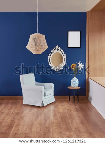 Dark blue wall interior, mirror lamp and furniture armchair with frame and picture. Wooden detail and brown parquet.