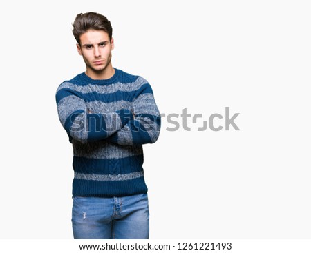 Young handsome man over isolated background skeptic and nervous, disapproving expression on face with crossed arms. Negative person.