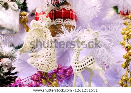 fabulous white New Year's angel with a deer on the background of a white Christmas tree, the theme of decorative toys and Christmas