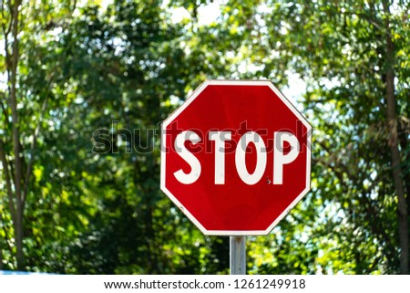 Stop sign with trees on background