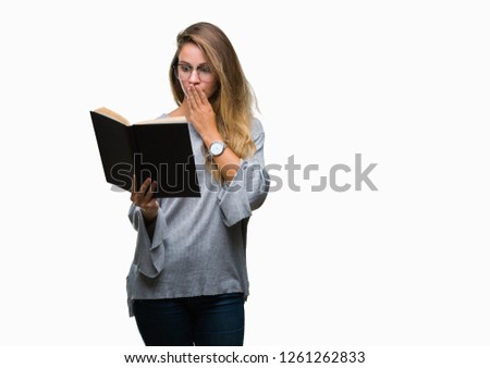 Young beautiful blonde woman reading a book over isolated background cover mouth with hand shocked with shame for mistake, expression of fear, scared in silence, secret concept