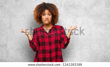 Young black afro woman confused and doubtful