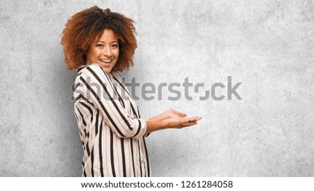 Young black afro woman holding something with hands