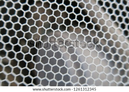 a part of an engine of a excavator behind a metal grid