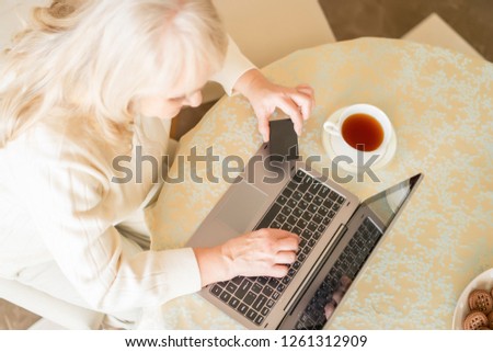 Top Vies On Elderly Woman Making Paying Transactions With The Help Of A Credit Card Over A Cup Of Tea.