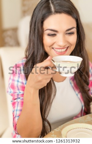 Attractive Woman Thinks And Looks Down While Drinking Tea In The Cafe.
