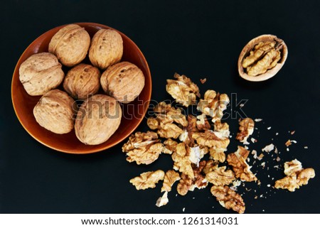 Greek walnuts on a black background, lie in a beautiful bowl