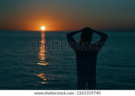 A woman admires the sea sunset             