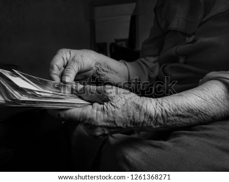 Old woman holding picture in hand. black and white