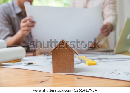 Architects engineer discussing on desk with blueprint. Team group on construciton site check documents and business workflow.house model for concept investment mortgage finance and home loan business