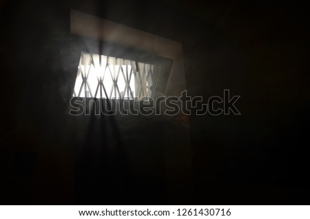 Abstract of mysterious window with smoke, shadow and sunny. The Strong light of the sun passes on black and white color.  