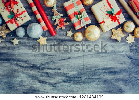 Christmas background with gift boxes golden balls decorations on the wooden board. New year texture.