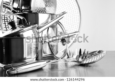 Stainless steel pots and utensils on table counter Royalty-Free Stock Photo #126144296