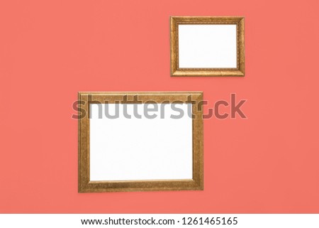 Frames with empty canvases on wall in modern art gallery, mockup for design. Living coral color
