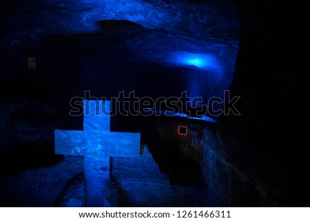 Stone cross with salt formations illuminated in blue tones in Salt Cathedral in Zipaquira Colombia