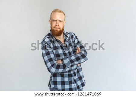 Red hair mature man standing isolated on grey wall crossed arms looking camera smiling curious