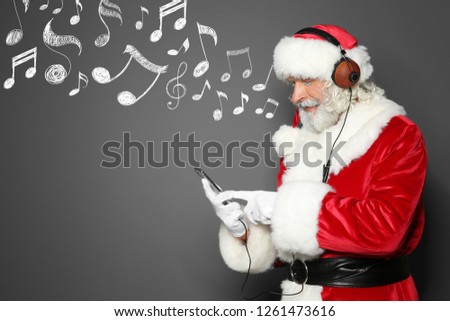 Santa Claus with headphones, smartphone and music notes on grey background, space for text. Christmas and New Year celebration