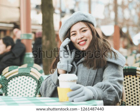 Attractive Asian woman drinking hot chocolate at coffee shop in winter day.