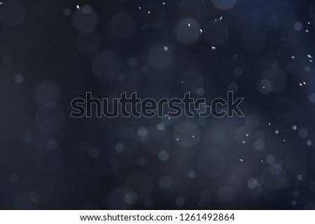Silver glitter on dark background. Bokeh effect