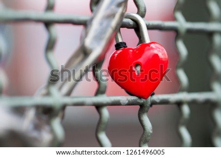 isolated love's lock in shape of a red heart at the fence of the Hohenzollern bridge in Cologne, Germany