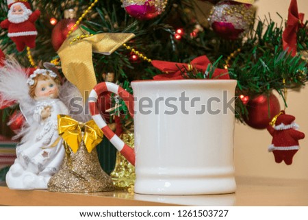 Close-up Christmas composition, Christmas tree decorated with beautiful toys, colorful bows and Santa figures, glowing lights of garland, bells and angels, wonderful mug