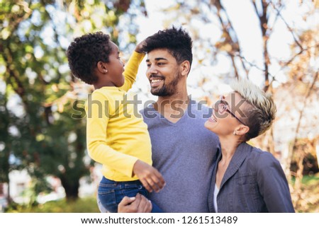 Happy young mixed race couple spending time with their daughter having fun