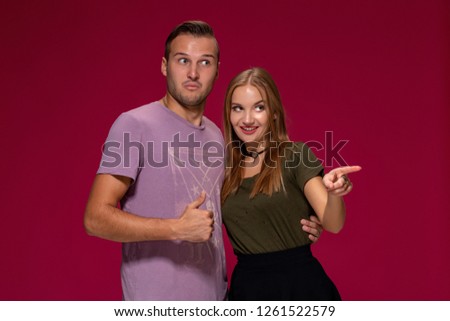 People, friendship, love and leisure concept - lovely couple with thumbs-up gesture on burgundy background