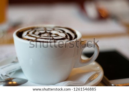 white cup with cappuccino, latte, coffee, mobile phone on a wooden table. wallpaper