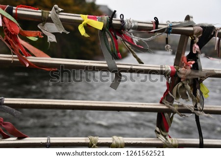 ribbons tied to bridge on river in ireland.  symbols of love