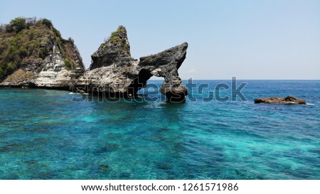 Rocky shore washed by the Turquoise sea. Shining blue sky. Summer time.