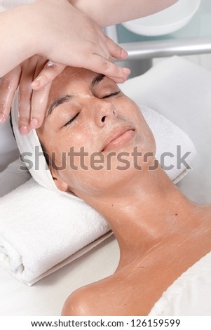 Young woman receiving face massage in dayspa, laying relaxed eyes closed.
