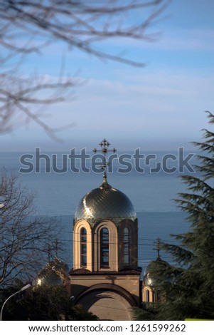 Bell tower of temple in the Bytkha micro-district of Sochi with background of the Black Sea