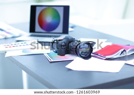 camera,fabric samples and sketches are on the desktop