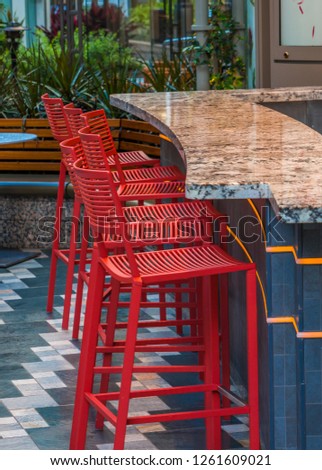A Row of Red Chairs at Granite Bar in a Patio