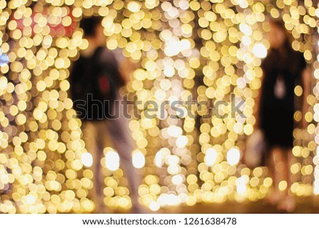 Blurred of twinkle light illumination tunnel has been decorating with silhouette of young couple